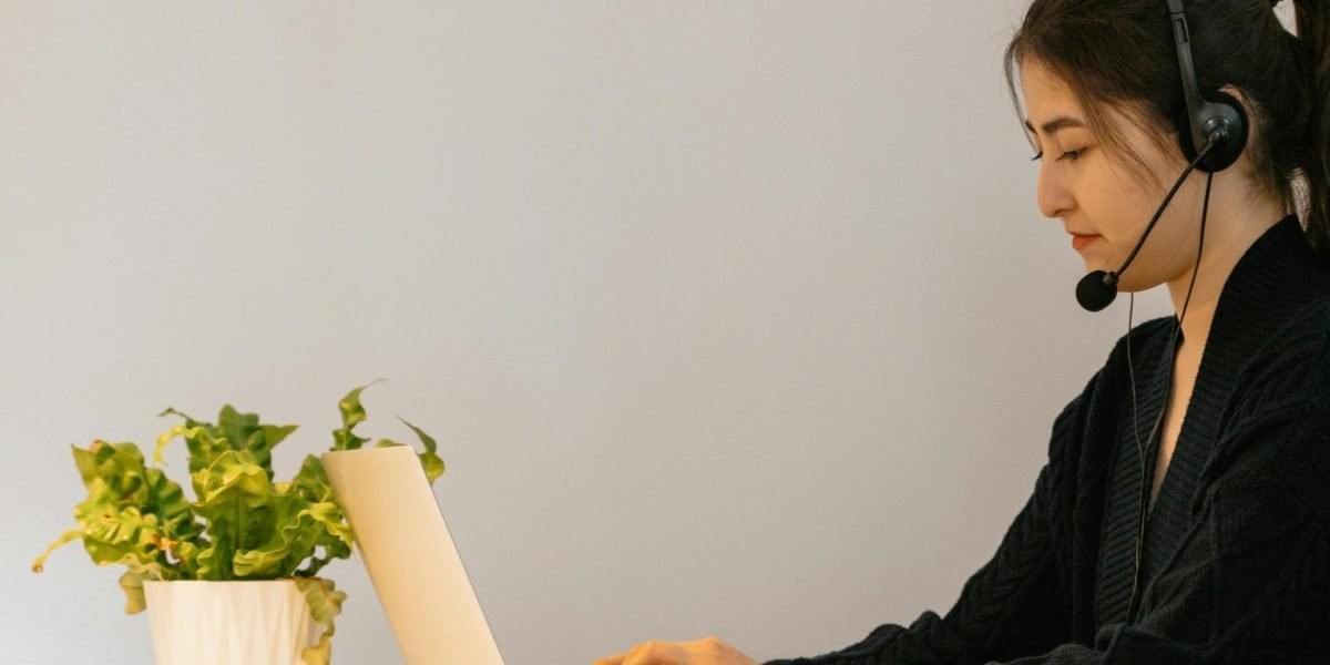 Remote appointment setter working at a home desk with a laptop and headset